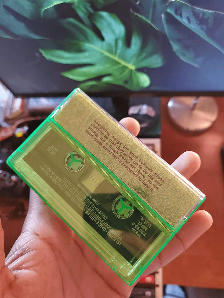 The back of the green case, showing the tape and the liner notes through it