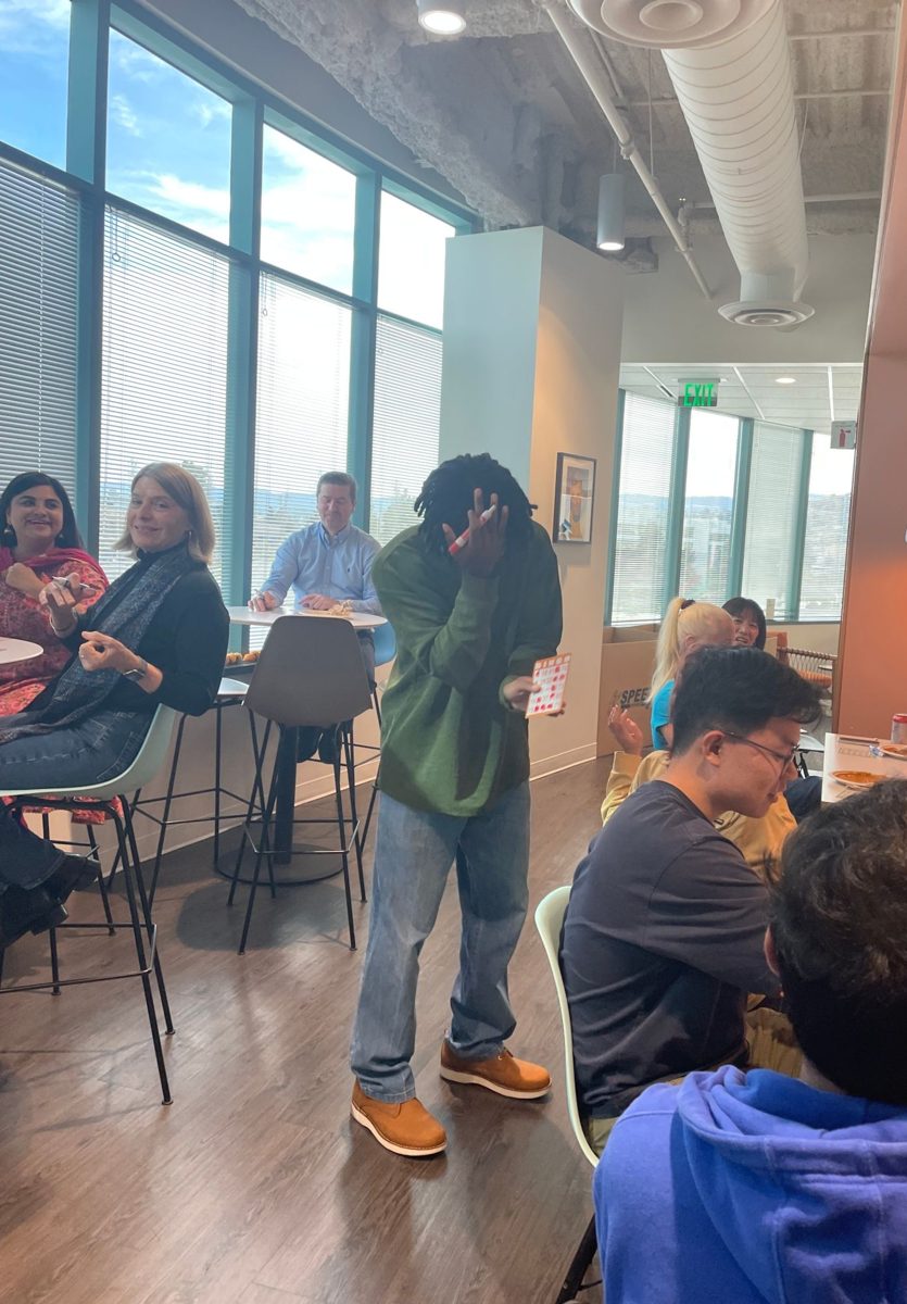 Bingo at the office, with one player hiding their face in mock embarrassment.