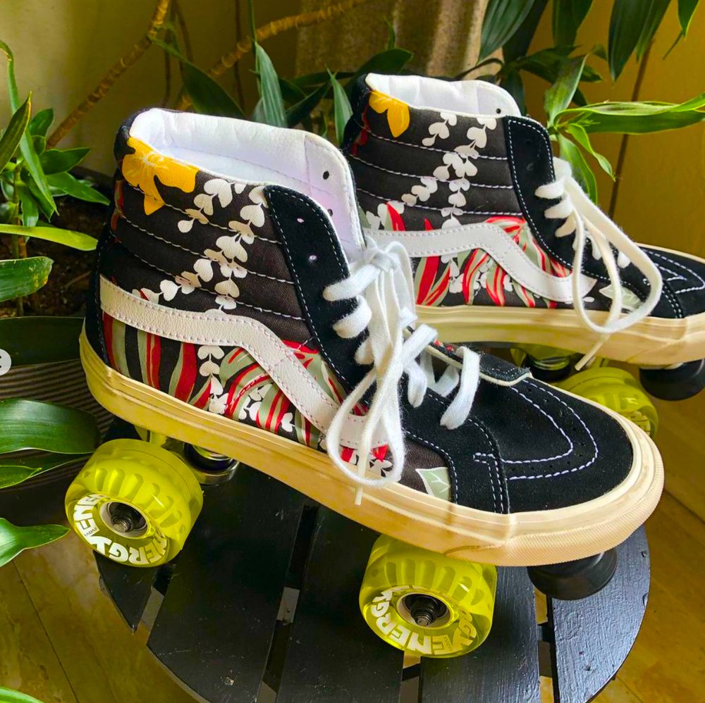 Black high-top Vans roller skates with a red and green print and yellow wheels