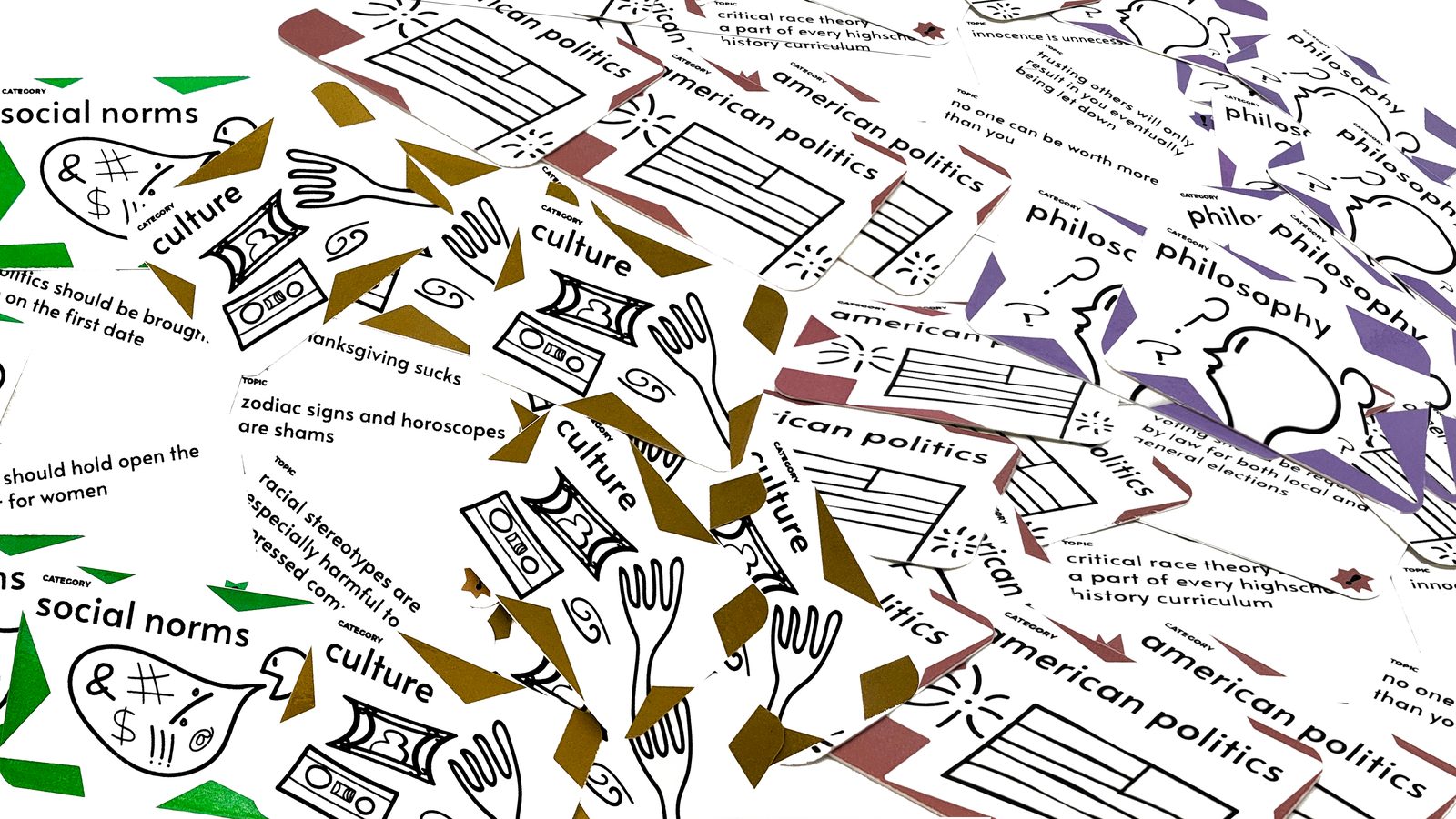 A pile of printed category cards up close: social norms, culture, american politics, and philosophy, fronts and topic backs